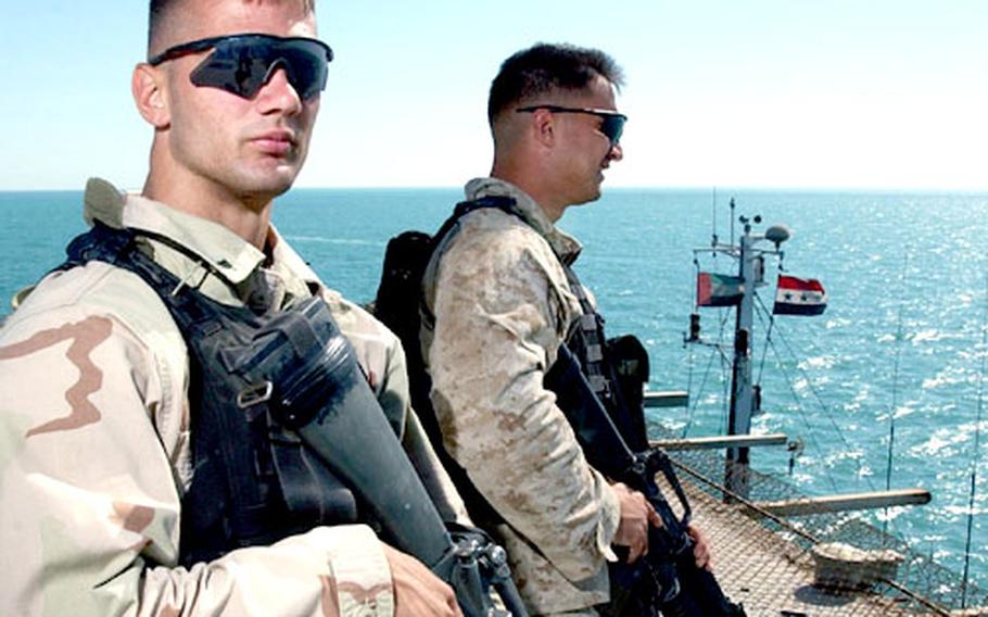 Lance Cpl. Christopher Kotulski and Cpl. Paul O'Donnell stand watch on the flight deck of the Al Basrah Oil Terminal.