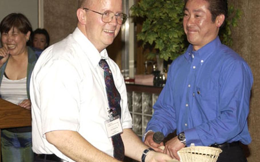 John Niemeyer, CNFJ political advisor, wins a raffle prize at the 7th annual CNFJ Regional Fire Department friendship dinner at the Yokosuka Naval Base Officer's Club.