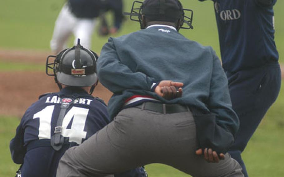 Senior Airman Jason Lambert, No. 14, prepares to receive a pitch from Senior Airman Eric Baxter during a baseball game at RAF Feltwell, England. A team of servicemembers plays in a British baseball league.
