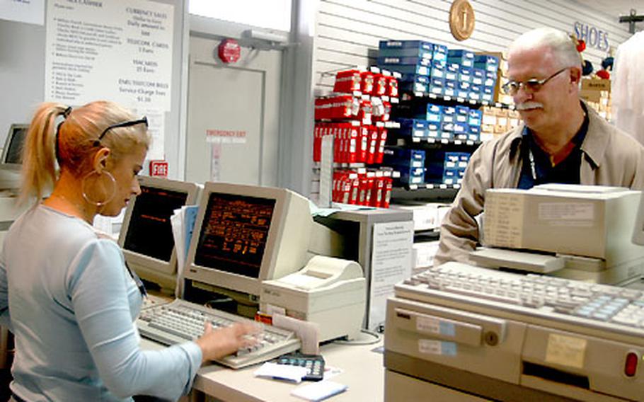 Dan Wyckoff, a Department of Defense civilian at Naples, Italy, buys gas coupons from Stefania D’Orso Monday at the Navy Exchange.