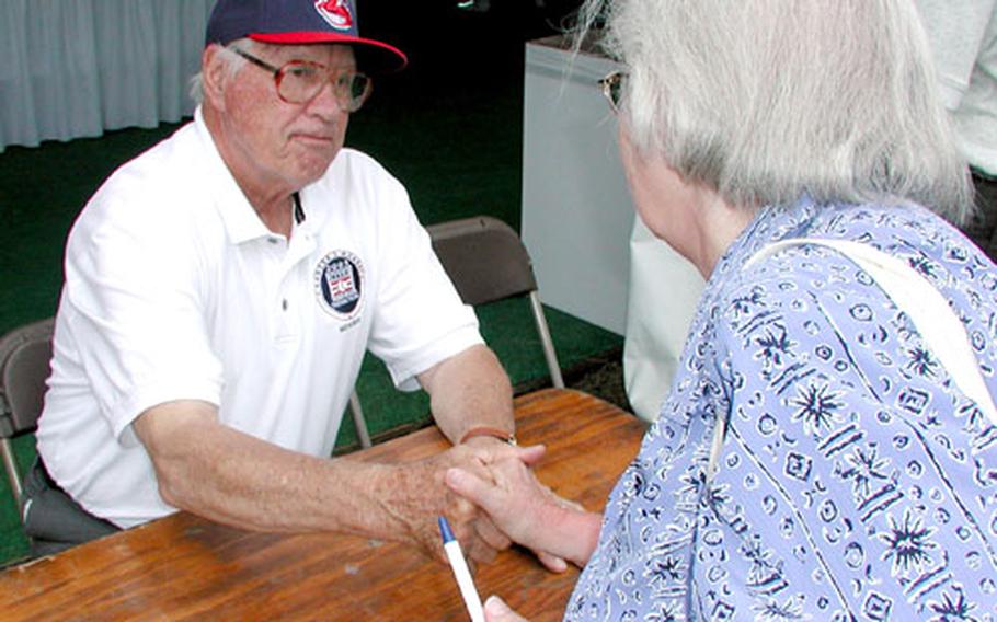 Baseball Hall of Famer Bob Feller greets a fan during an autograph session Sunday at the National World War II Reunion in Washington. Feller, former major leaguer Monte Irvin and Negro League player Buck O'Neil — all World War II veterans — were panelists at a discussion on veterans as baseball players.