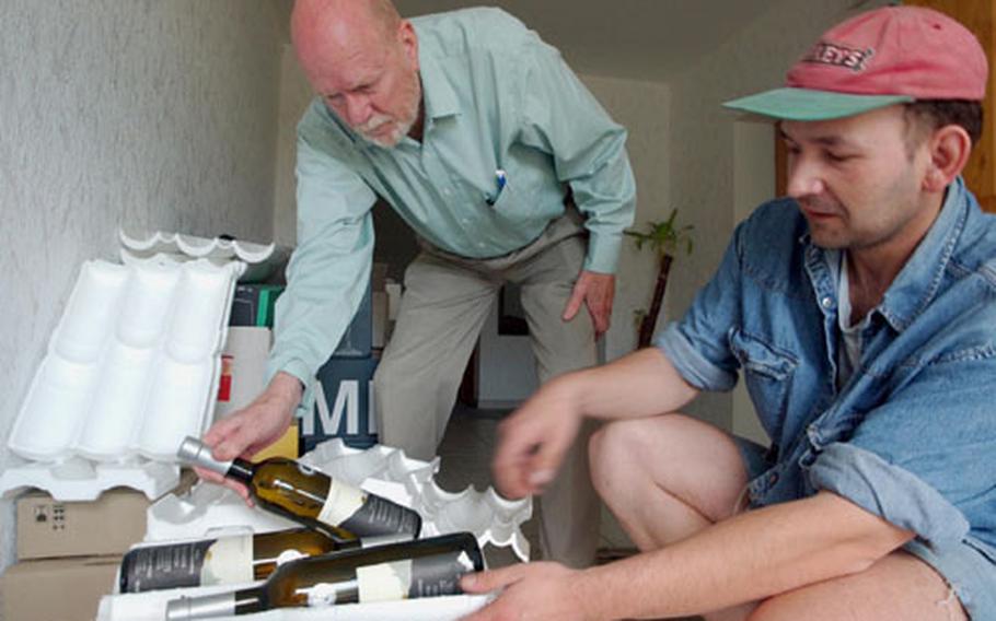Glen Riddle and his assistant, Kristan Reiss, pack bottles for shipment to the United States. Riddle, a retired U.S. Air Force serviceman, runs a company that packs and ships wine collections for servicemembers moving back to the States.