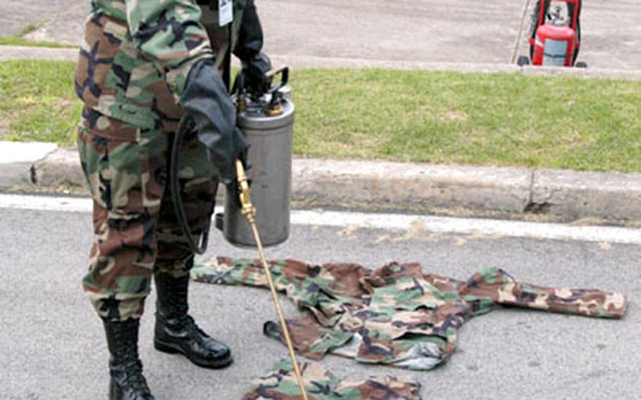 Pfc. Jessica Martin of the 702nd Main Support Battalion sprays Permethrin insect repellent on a uniform at Camp Casey, South Korea.
