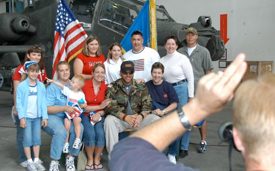 Scott Rouch, of the 98th Area Support Group Public Affairs Office, snaps a photo of concertgoers with Toby Keith, sitting in the front row, on Monday in Illesheim, Germany. The crew rushed groups of people through to accommodate the long line of fans wanting to have their pictures taken with the country music star. Keith, along with rocker Ted Nugent, performed a free Memorial Day concert in Illesheim for thousands of soldiers and family members.