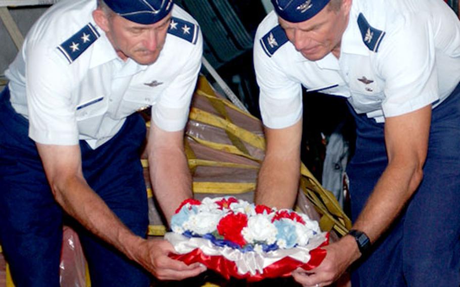 Air Force Reserve Maj. Gen. Edward Mechenbier, left, and Col. Gregg Sanders, 13th Air Force vice commander, lay a wreath on one of two caskets containing the remains of military members killed in Vietnam during a repatriation ceremony Saturday. Mechenbier, a Vietnam POW, decided to end his 40-year military career by returning to Hanoi, Vietnam, and retrieving remains of fallen comrades.