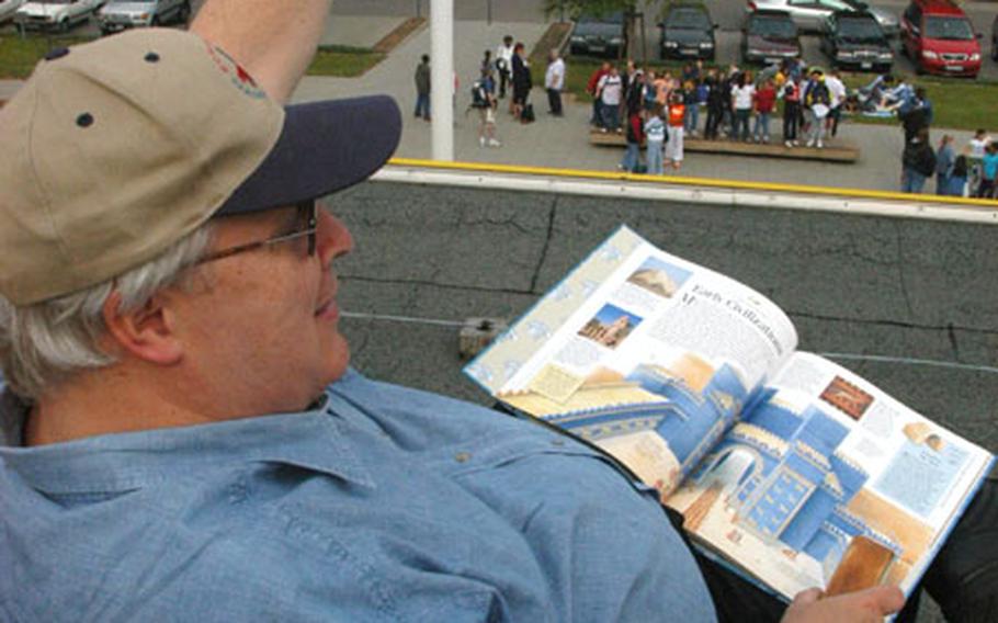Principal Bob Nance waves to students at Patrick Henry Elementary School Friday from the school roof. Nance challenged his students that if they read enough books throughout the school year, he would spend the day on the roof.