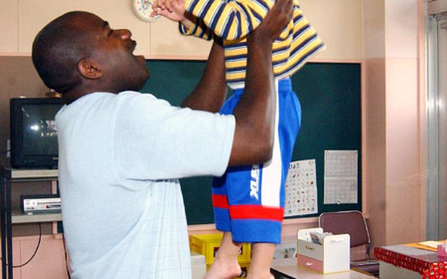 Gunnery Sgt. Jason E. Vinson, a food services manager at Iwakuni Marine Corps Air Station, enjoys interacting with a young Japanese boy recently as another looks on and has a hearty laugh at Mangyoji Hoikuen Preschool in Iwakuni city. The children at this school and 15 other preschools in the area, get at least two opportunities each month to interact with servicemembers who participate in the Adopt a Preschool Program.