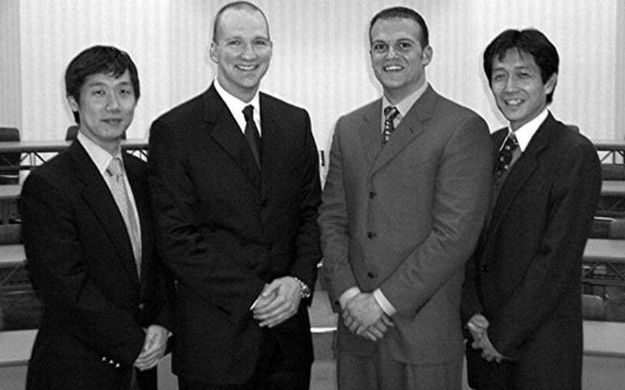 Navy Lt. Cmdrs. Paul Hladon, center left, and Andrew Schiemel, center right, stand with the translators for their book's "Language and Philosophy of Western Medicine," publicity photo. The translators are Masayuki Yoshida, left, and Tomohiro Morio. All four are physicians.