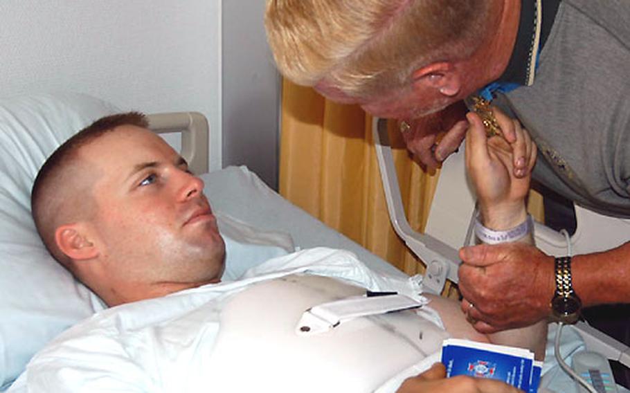 Army 1st Lt. Dwight Mears, who was injured Sunday when his Black Hawk helicopter crashed in Iraq, touches the Medal of Honor worn by Sammy Davis, who earned the medal in 1967 for his actions in Vietnam. Davis and two other Medal of Honor recipients visited wounded soldiers at Landstuhl Regional Medical Center, Germany, on Tuesday.