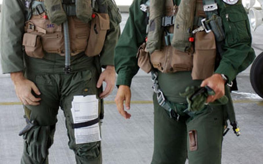 Air Force Capt. Derek Innarelli, left, from Kadena Air Base’s 44th Fighter Squadron, walks with Lt. Gen. Kunihiro Oda, of the Japanese Air Self-Defense Force after the two performed an air-refueling mission Tuesday aboard an F-15C from Kadena.