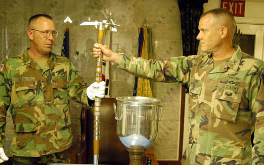 Staff Sgt. Ricky Bryant, left, of the 2nd Infantry Division Museum, receives Hitler's walking stick and the Sink Grail from 1-506th commander Col. David Clark at Camp Greaves on Thursday. Units headed to Iraq are storing many of their trophies and unit symbols until their return.