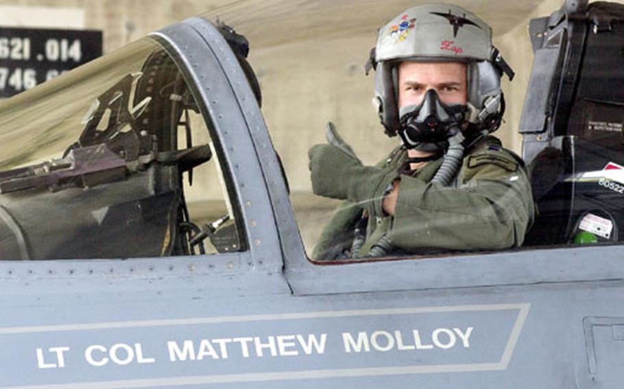 Air Force Lt. Col. Matthew Molloy, commander of the 67th Fighter Squadron gives a ‘thumbs up’ sign to his maintenance crew Thursday after returning to Kadena Air Base after his last flight with the squadron. Last week, the squadron, known as the “Fighting Cocks,” won Raytheon’s Hughes Achievement Award, given annually to the best air defense squadron in the U.S. Air Force.