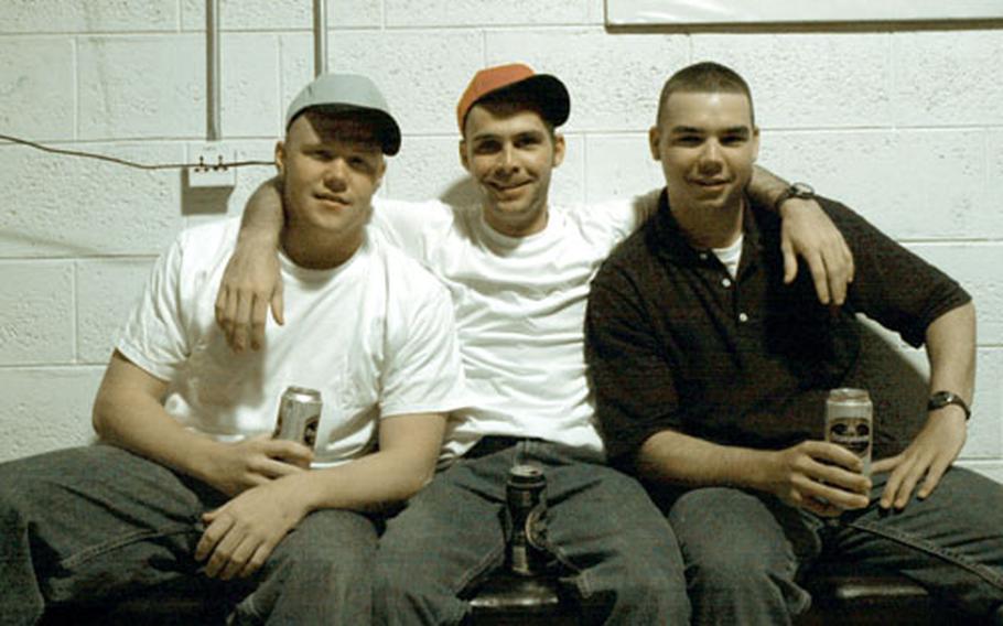 From left, Army Spcs. Jesse Greene and Robert Swanson, and Pfc. Darren "Moose" Ripley relax while having a beer during their four-day rest and recuperation trip to Camp As Sayliyah, Qatar.