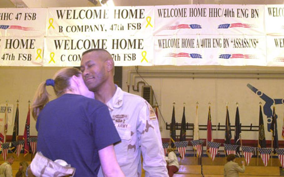 Just home after 15 months in Iraq, Capt. Walter Dunn dances an impromptu slow dance with his wife, Eden, in Baumholder's gym.