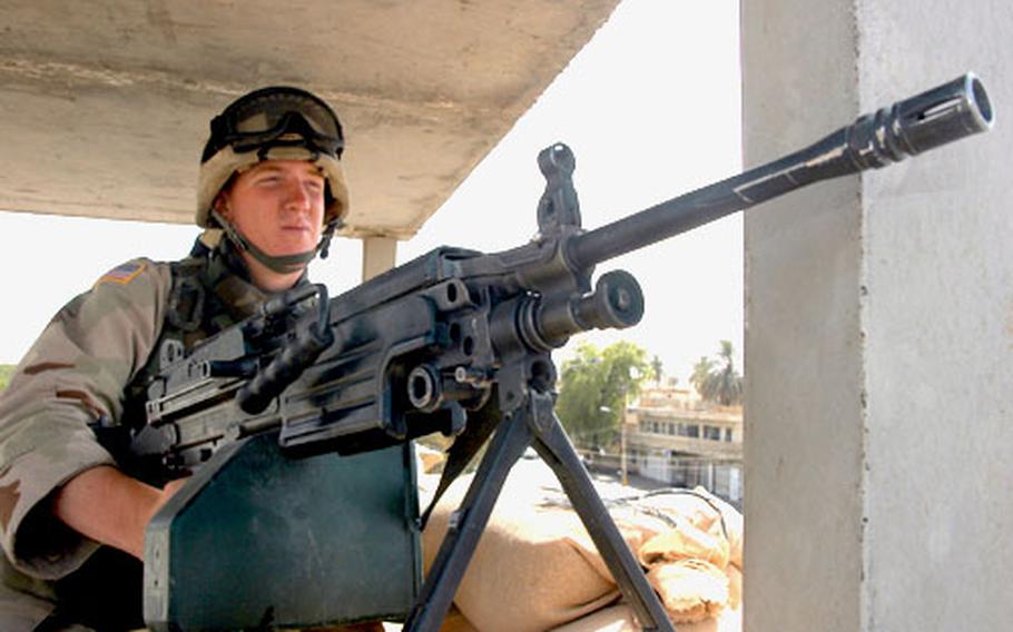 Pfc. Clinton Rope, 20, of Clarinda, Iowa, looks over a Baghdad neighborhood Sunday from atop an Iraqi police station. U.S. military police maintain security at the police station during daylight hours. However, after dark, the troops leave and the station often comes under attack.