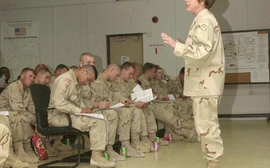 Army Master Sgt. Ellie Walbridge briefs troops just arriving in Qatar for the beginning of their four-day Fighter Management Pass. Walbridge is the program's Morale, Welfare and Recreation supervisor.