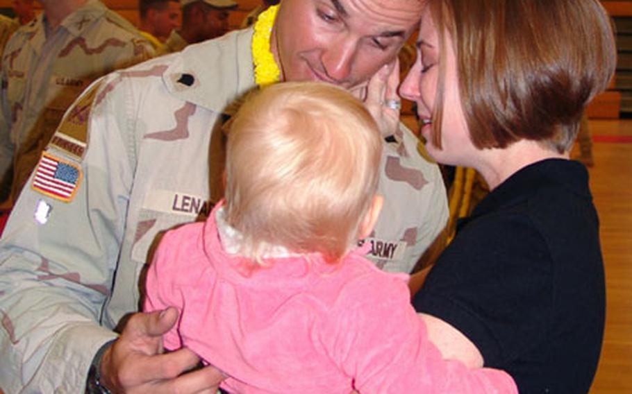 Spc. Jesse D. Lenard, a member of the 1st Battalion, 6th Infantry Regiment out of Baumholder, Germany, gets a tearful welcome home from his wife, Traci, and their daughter.