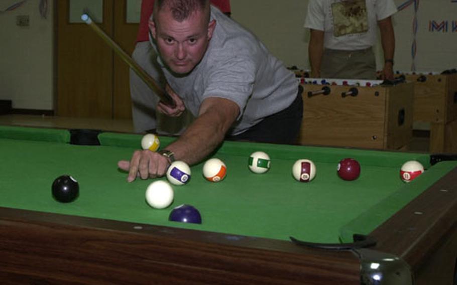 Sgt. Rick Weaver, 1450th Transportation Company, works on clearing the table during the championship pool match at the Zone I Community Center on Camp Arifjan. Weaver won the match, which was part of Morale, Welfare and Recreation's game night in celebration of the Fourth of July.