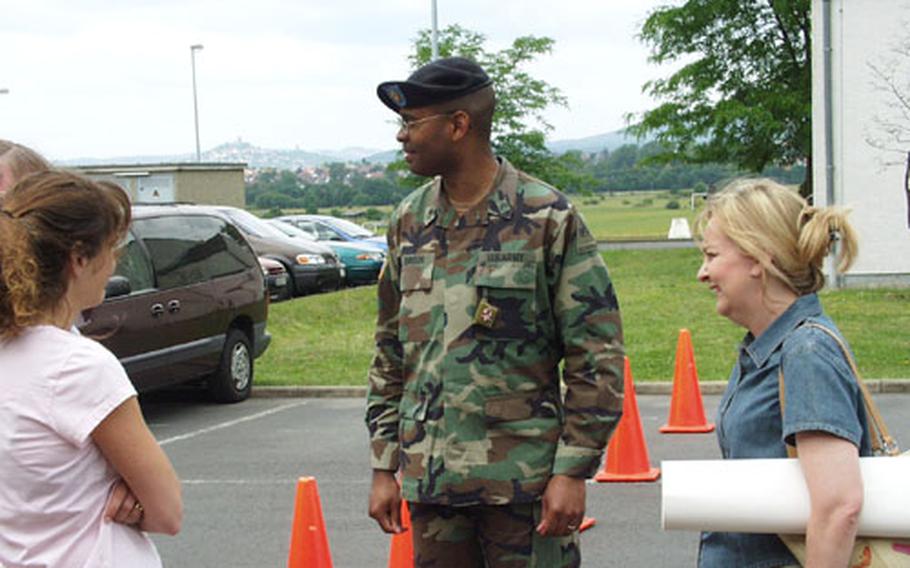 Spouses in Giessen view Staff Sgt. Anthony Johnson as an indispensable bridge between families and the military. Johnson, a howitzer section chief, is currently the family readiness liaison for the 2nd Battalion, 3rd Field Artillery Regiment, a position he assumed last year while recuperating from a gunshot wound suffered in a Baghdad raid. Pictured with Johnson (center) are Gina Anderson, left, a family readiness group leader, and Tina Rabena, the FRG leader for the battalion.