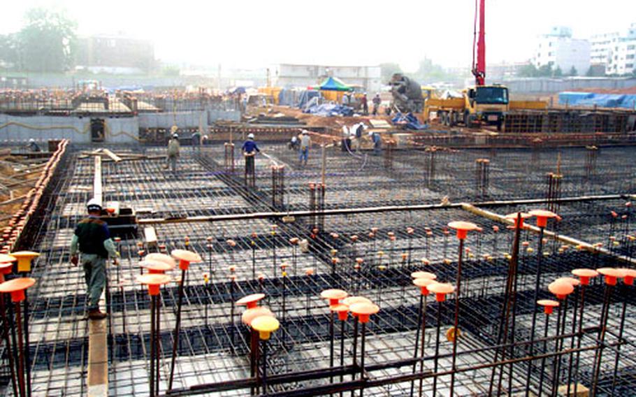 At Camp Humphreys, South Korea, workers prepare to pour concrete for part of a twin, six-story barracks-dining hall complex, set to open in February 2006. Each barracks building will house up to 204 troops at the U.S. Army helicopter base, which is set for major expansion in the coming years as the U.S. military shifts thousands of troops south into the Camp Humphreys area.