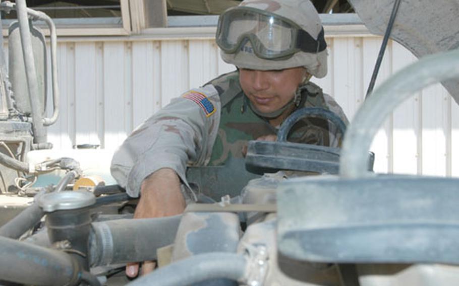 Spc. Yavel Pereira, Headquarters and Headquarters Company, 1st Battalion, 501st Aviation Regiment, checks fluid levels on his Humvee Friday. Vehicle operators have done frequent and regular maintenance on the vehicles in the weeks leading up to the unit's convoy from Baghdad to Kuwait as they head they to head their home stations in Germany.