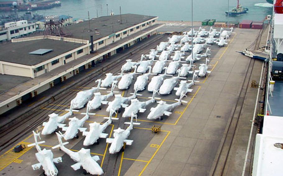 Pierside at the Army's Pier 8 in Pusan, South Korea in this September 2002 photo, AH-64 Apache helicopters await loading onto ships that will take them to the United States. Pier 8 is currently playing a role in plans to ship the equipment of the 2nd Infantry Division's 2nd Brigade Combat Team from South Korea to Iraq.