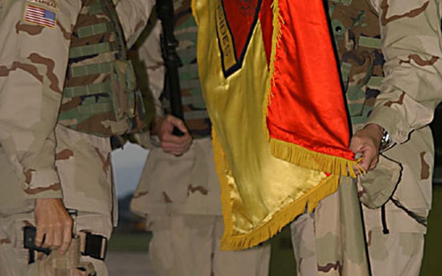 1st Armored Division commanding general Maj. Gen. Martin Dempsey, left, and Command Sgt. Maj. Michael Bush, right, unfurl the division's flag Wednesday at Wiesbaden Army Airfield. Dempsey returned from Iraq Wednesday along with a small group of Wiesbaden-based soldiers. About 500 soldiers arrived Wednesday in other 1AD communities in Hanau, Baumholder and Friedberg.