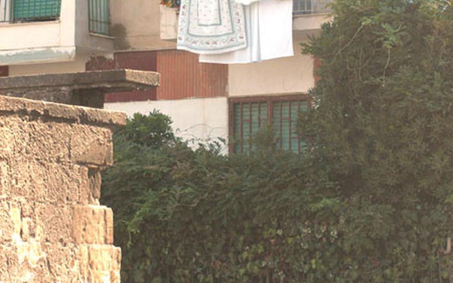 Typical sites in Naples, Italy, and surrounding suburbs such as this one near Licola: clothes strung up from balconies to dry in the sea air, garbage spilling out of trash containers onto the roadside and stray dogs.