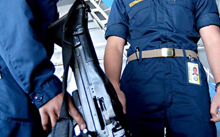 Torpedoman’s Mate 3rd Class Marcus Young of Shannon, Miss., gives a safety brief on the M-60 machine gun to Midshipmen 3rd Class Zachary Weinman, of Annapolis, Md., on the fantail aboard USS Enterprise. Enterprise is one of seven aircraft carriers participating in Summer Pulse ’04. Weinman is an ROTC student volunteering on the ship.