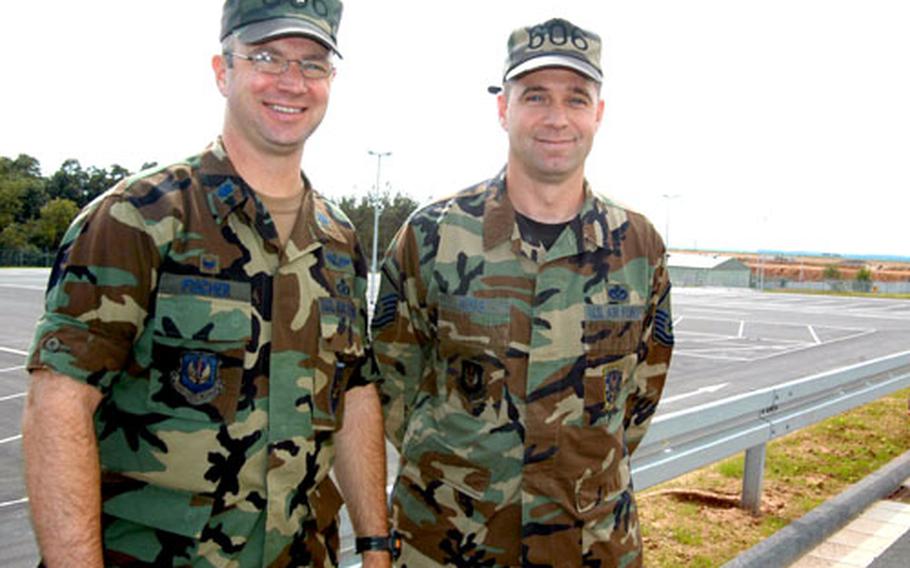Lt. Col. Scott Fischer, commander of the 606th Air Control Squadron at Spangdahlem, and Master Sgt. Patrick Ross stand in front of a massive new lot for the squadron's vehicles. After years spread out in 19 different buildings, the squadron will now call three new Spangdahlem buildings home.