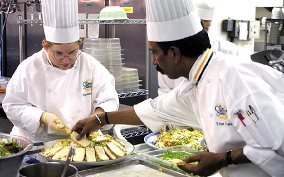 Chefs Elizabeth Briggs, at left, and Prem Kuma, from the Culinary Institute of America, prepare a Vietnamese dish at the Naval Air Facility Atsugi Officers' Club Wednesday.