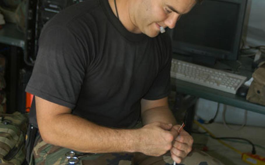 Tech. Sgt. Jamie Killingsworth of the 269th Combat Communications Squadron, Ohio Air National Guard, splices cable for a communications center Thursday at the Silver Flag exercise at Ramstein Air Base, Germany. About 200 airmen from U.S. Air Forces in Europe and beyond are taking part in the training to prepare for deploying to a bare base.