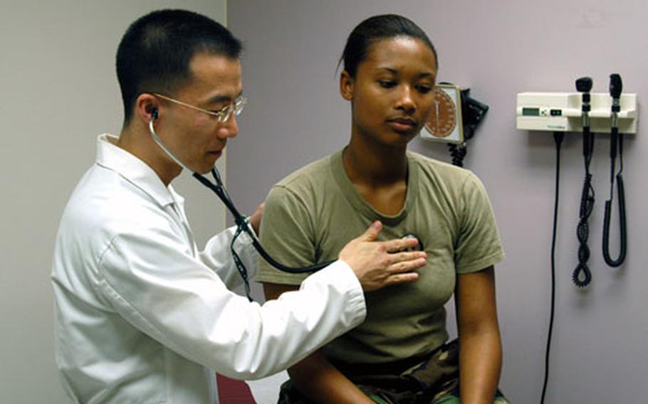 Capt. Chin Yi checks the heart beat of Spc. Shamea Skinner during a routine sick call at the Wood Medical Clinic on Camp Walker in Taegu, South Korea, on Thursday.