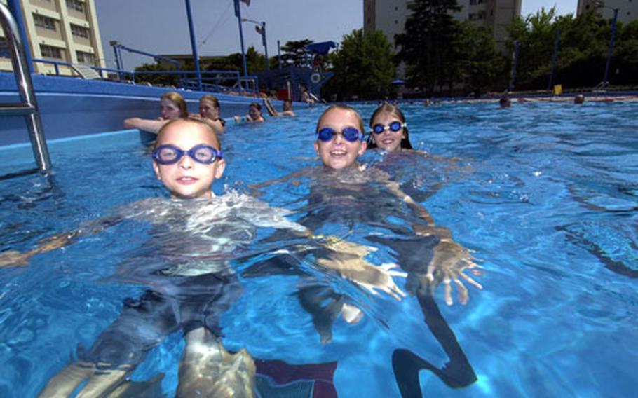 Erik Black, 8, Jason Black, 10, and Alison Wallach, 9, beat the heat while swimming at the pool at Yokosuka Naval Base Saturday.