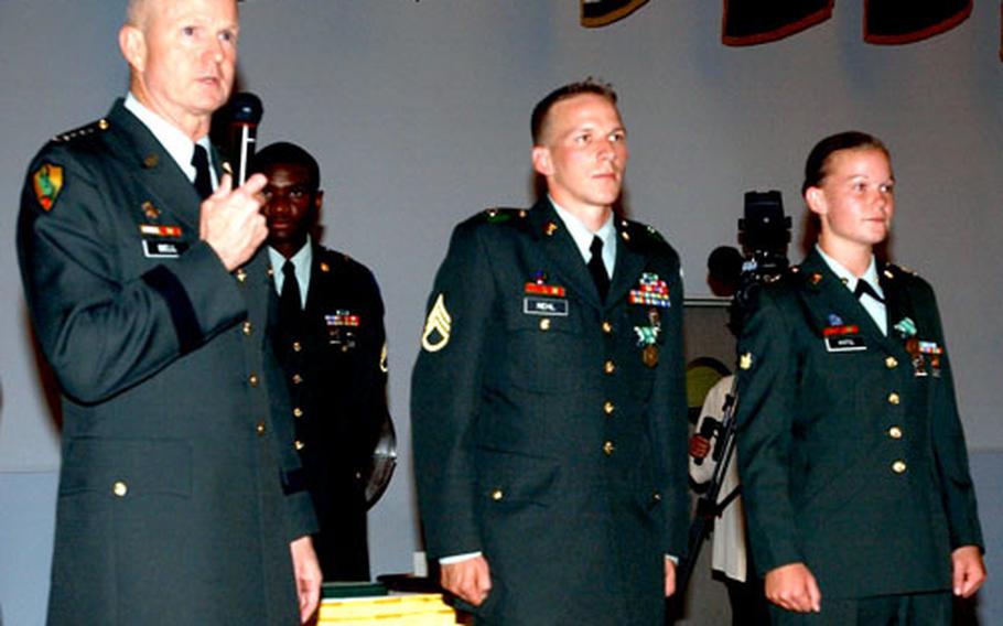Gen. B.B. Bell, commander, U.S. Army Europe, speaks after awarding the Army Commendation Medal for meritorious achievement to Staff Sgt. James Rehl, 67th Forward Surgical Team, and Spc. Megan Pitts, Headquarters and Headquarters Detachment, 14th Transportation Battalion.