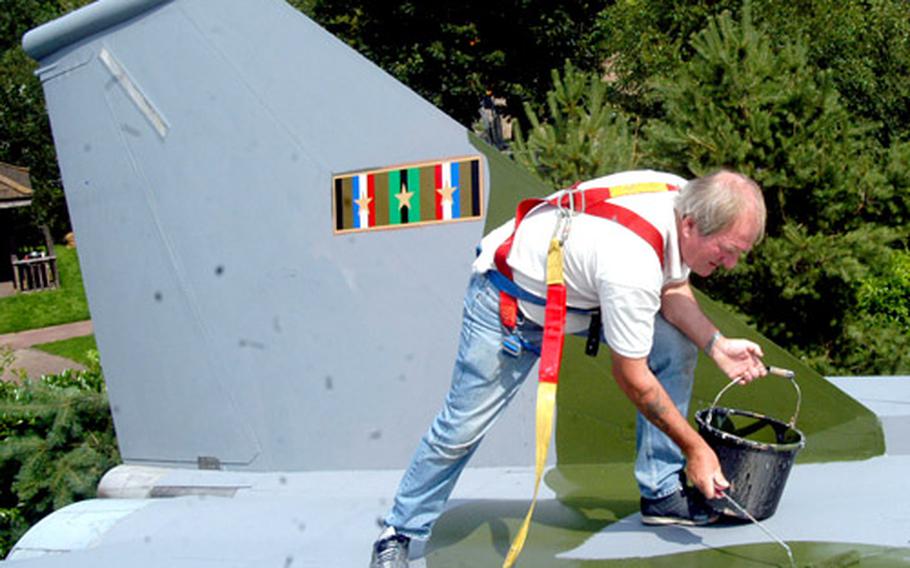 Ken Gibbs of Protective Maintenance Systems in England on Wednesday paints the F-111 that is part of RAF Lakenheath’s static display of aircraft. The base was named the best-looking USAFE base.