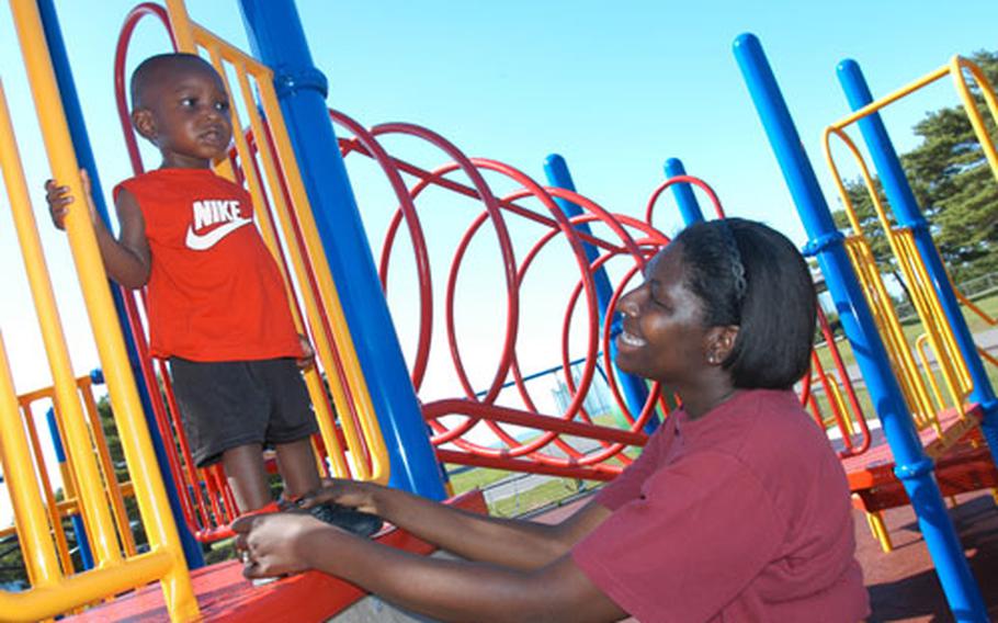 Petty Officer 2nd Class Aquinor Hollingsworth plays with 1-year-old Corey Hollingsworth Jr. on the new playground equipment at Misawa Air Base's Davey Jones' Locker.