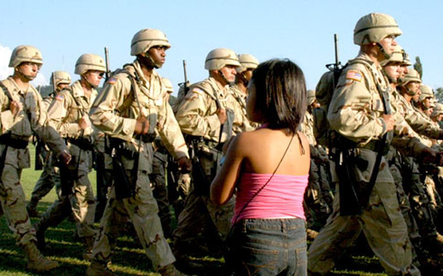 A young girl looks for her father among Iraq-bound 2nd Infantry Division soldiers parading at Camp Casey shortly before their departure.