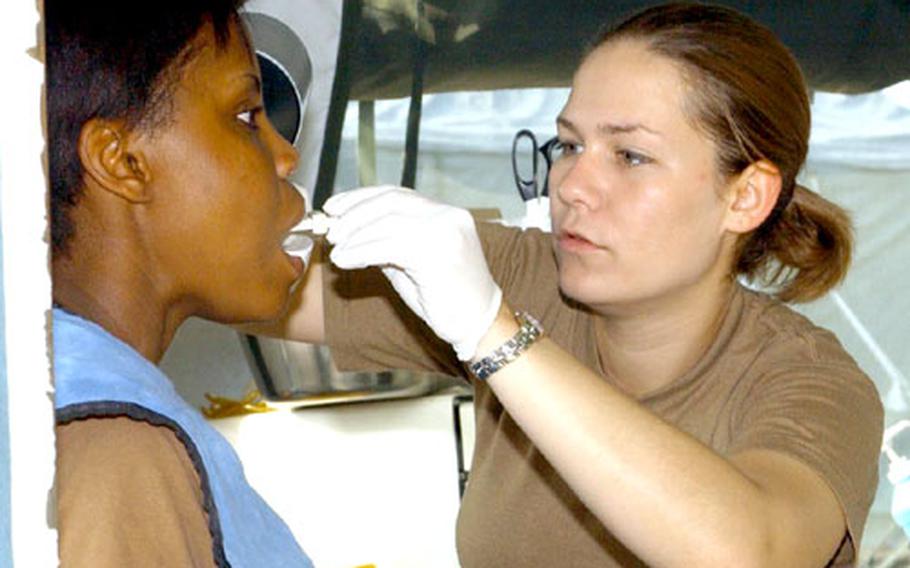 Spc. Bridget McClure prepares Spc. Erica Morgan for an X-ray before removal of her wisdom teeth Saturday at the Bulwark '04 exercise at the Novo Selo Training Area, Bulgaria.