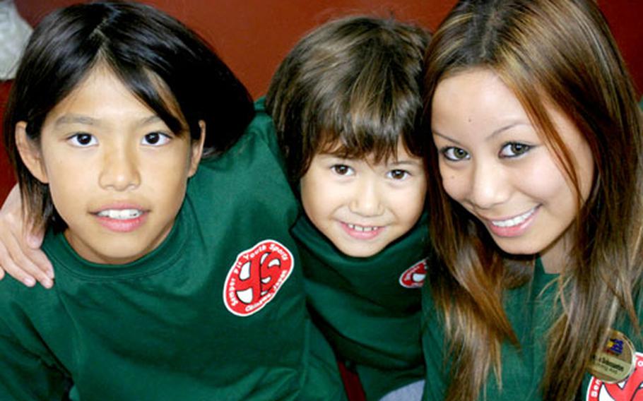 Saki Kinjo, 10, Margo Pauli, 11, and Frances Delossantos, 16, left to right, from Kubasaki High School hug in a huddle Tuesday at the Teen Center on Camp Foster to discuss survival tactics for a game of dodge ball. Six teams made up of 30 American and Japanese children competed at the teen center during a three-day youth summer camp sponsored by Marine Corps Community Services Okinawa.