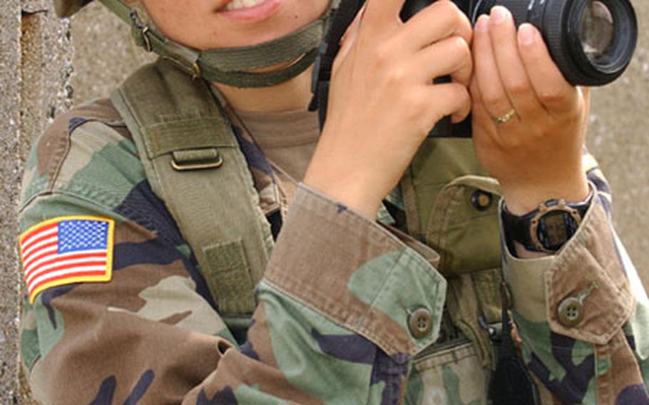 Sgt. Teodora Mocanu shoots photos, not weapons, at the Military Operations Urban Terrain course during Bulwark '04 at the Novo Selo Training Area, Bulgaria.