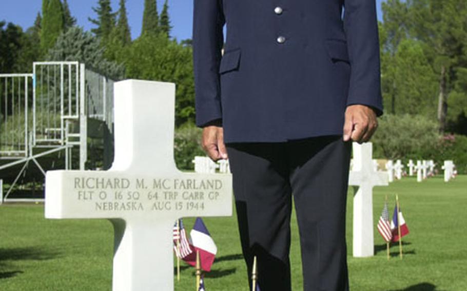 Air Force Master Sgt. David Zibell, a member of the 774th Expeditionary Air Base Group in Istres, France, stands beside his grandfather's grave at Rhone American Cemetery in Draguignan, France. About 1,500 Americans and French on Saturday evening commemorated the 60th anniversary of the Allied landing in southern France.