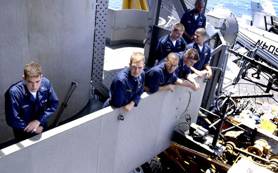 U.S. Navy midshipmen enjoy the view from vultures’ row as Carrier Air Wing 5 Super Hornets get ready to launch and land on the Kitty Hawk flight deck. From left are Yuval Fleming, Tyler Croft, Frederick Espy, Michael Garcia, Daniel Tischler, Christopher Pratt and Jason Mason.