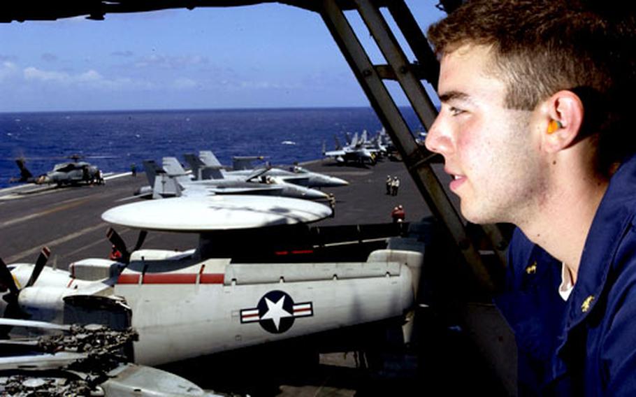 Midshipman 1st Class Yuval Fleming of Tucson, Ariz., enjoys the view from vulture's row as an SH-60 Seahawk helicopter from Helicopter Anti-submarine Squadron 14 prepares to launch from the flight deck of the USS Kitty Hawk.