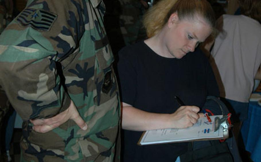 Shari Nance fills out a form so she can stay in touch with other spouses when her husband, Tech. Sgt. Randy Nance, left, goes downrange. Nance, of Spangdahlem's 606th Air Control Squadron, is deploying in the next AEF rotation.