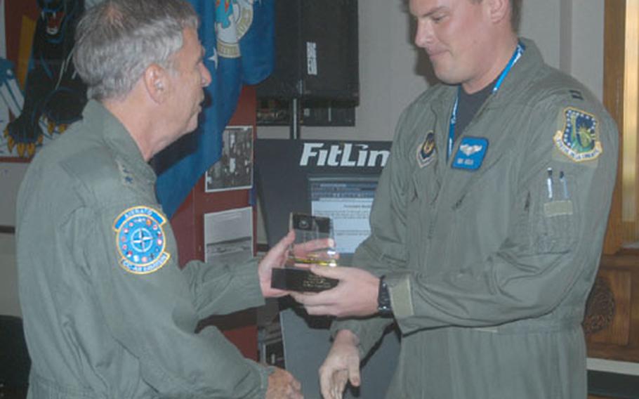 Capt. Ben Heslin, an F-15E Strike Eagle pilot with the 492nd Fighter Squadron at RAF Lakenheath, England, accepts an award Thursday from Gen. Robert H. "Doc" Foglesong. The award was for Heslin's performance in the Excalibur bombing competition held in England.