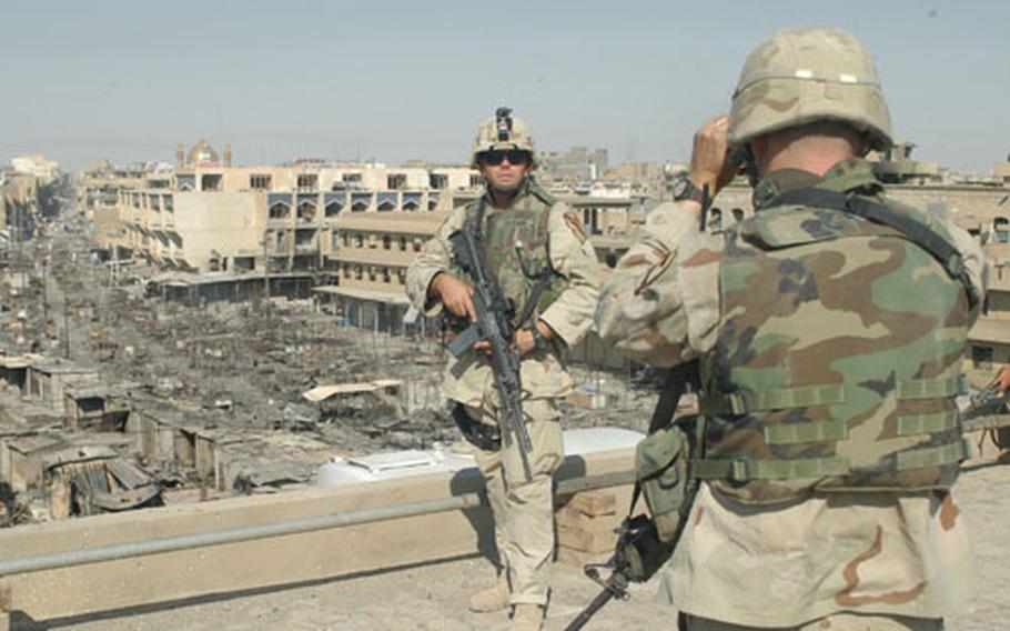 Staff Sgt. Michael Sherman, 28, of Hawaiian Gardens, Calif., has his photo taken by Sgt. Jim Davis, 34, of Kokomo, Ind., in front of the gold-domed Imam Ali mosque in Najaf, Iraq, Friday. Earlier that morning the soldiers found out that an agreement was reached to remove militia members around the mosque.