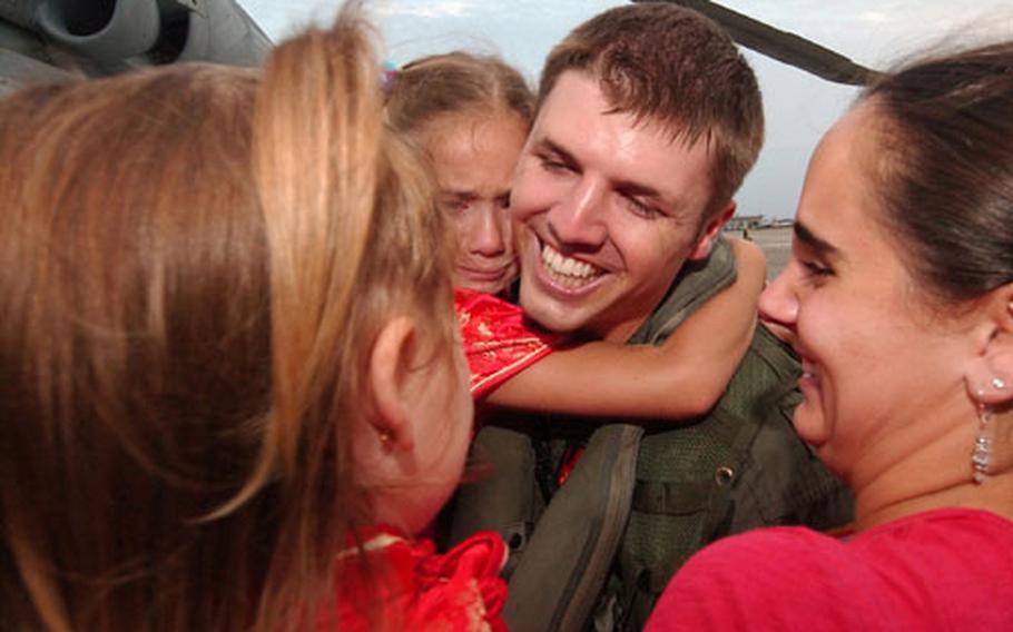 Lt. Shaun Lynch and family — wife Jessica, six-year-old daughter Siena, and two-year-old Isabella — embrace Friday after he returned from a five-month deployment.