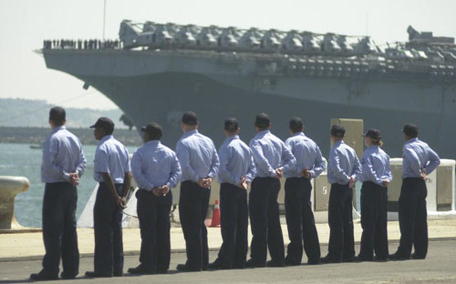 Sailors wait for the amphibious assault ship USS Wasp to pull into Naval Station Rota, Spain’s port on Tuesday.