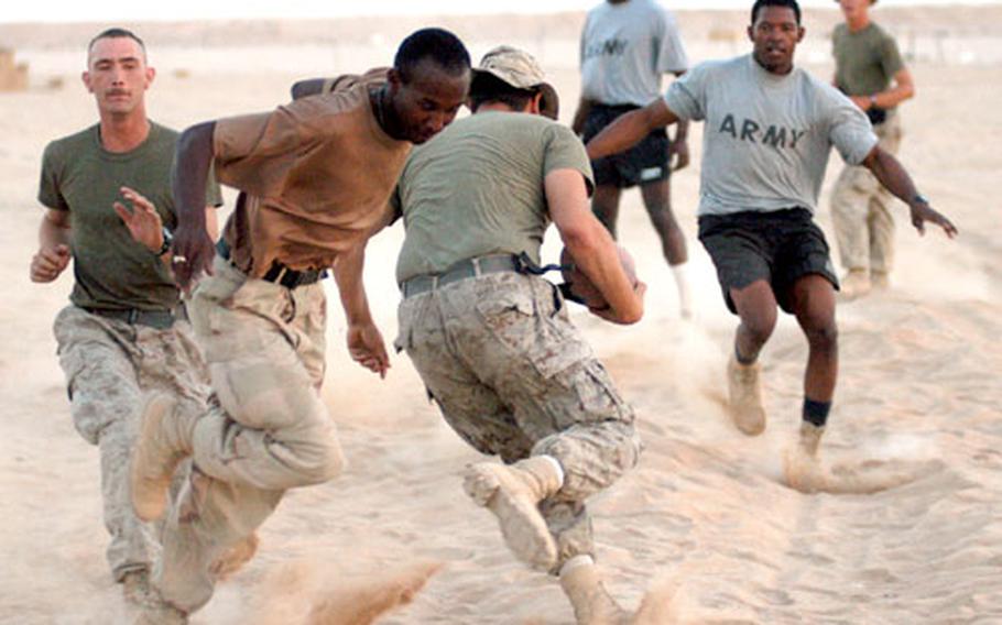 A Marine tries to break through the Army line Tuesday night during a football game between the 24th Marine Expeditionary Unit and units from the 2nd Battalion, 7th Cavalry Regiment.